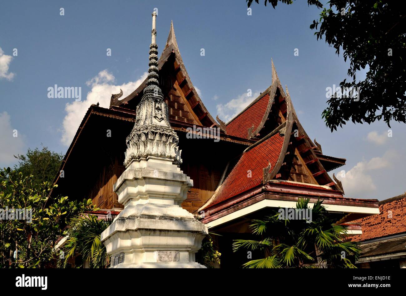 Ayutthaya, Thailand:    White Chedi with ringed spire and teak wood monastic house with high gables and chofahs Stock Photo
