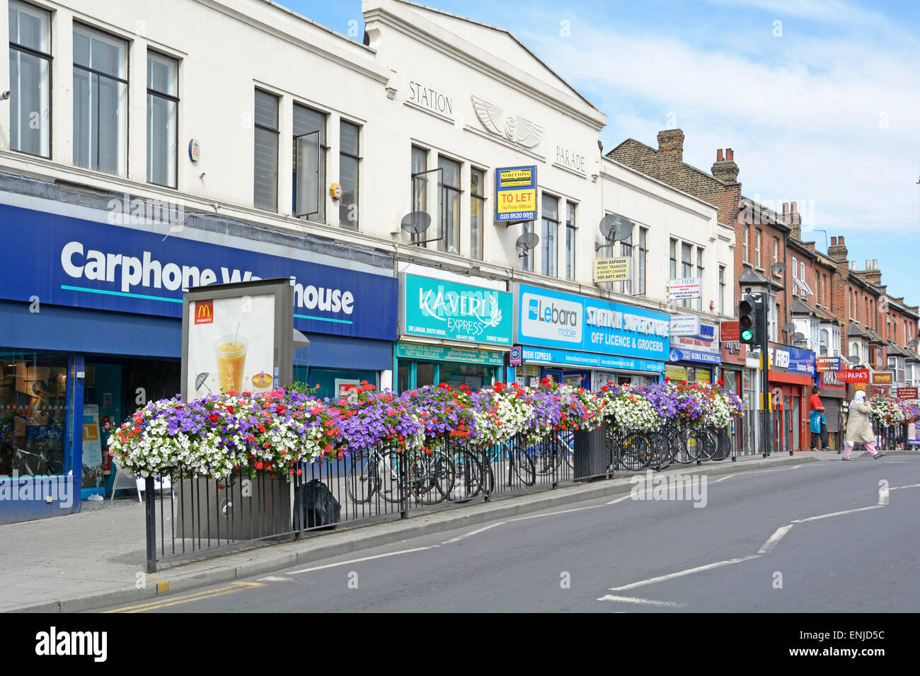 Station Parade shops railings and summer flowers opposite East Ham