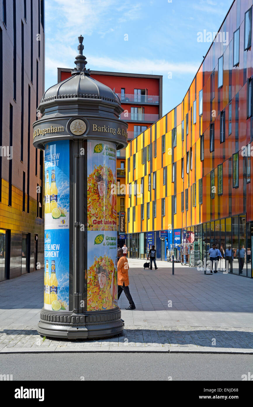 Cylindrical advertising morris column inscribed Barking & Dagenham with colourful modern architecture Barking town centre England UK previously Essex Stock Photo