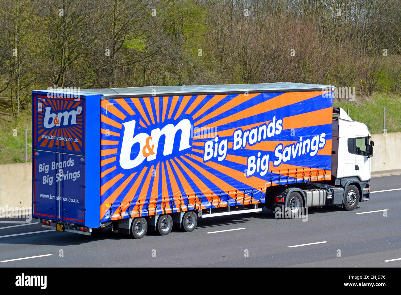 Articulated B M store delivery trailer and lorry truck driving along Articulated B M store delivery trailer and lorry truck driving along