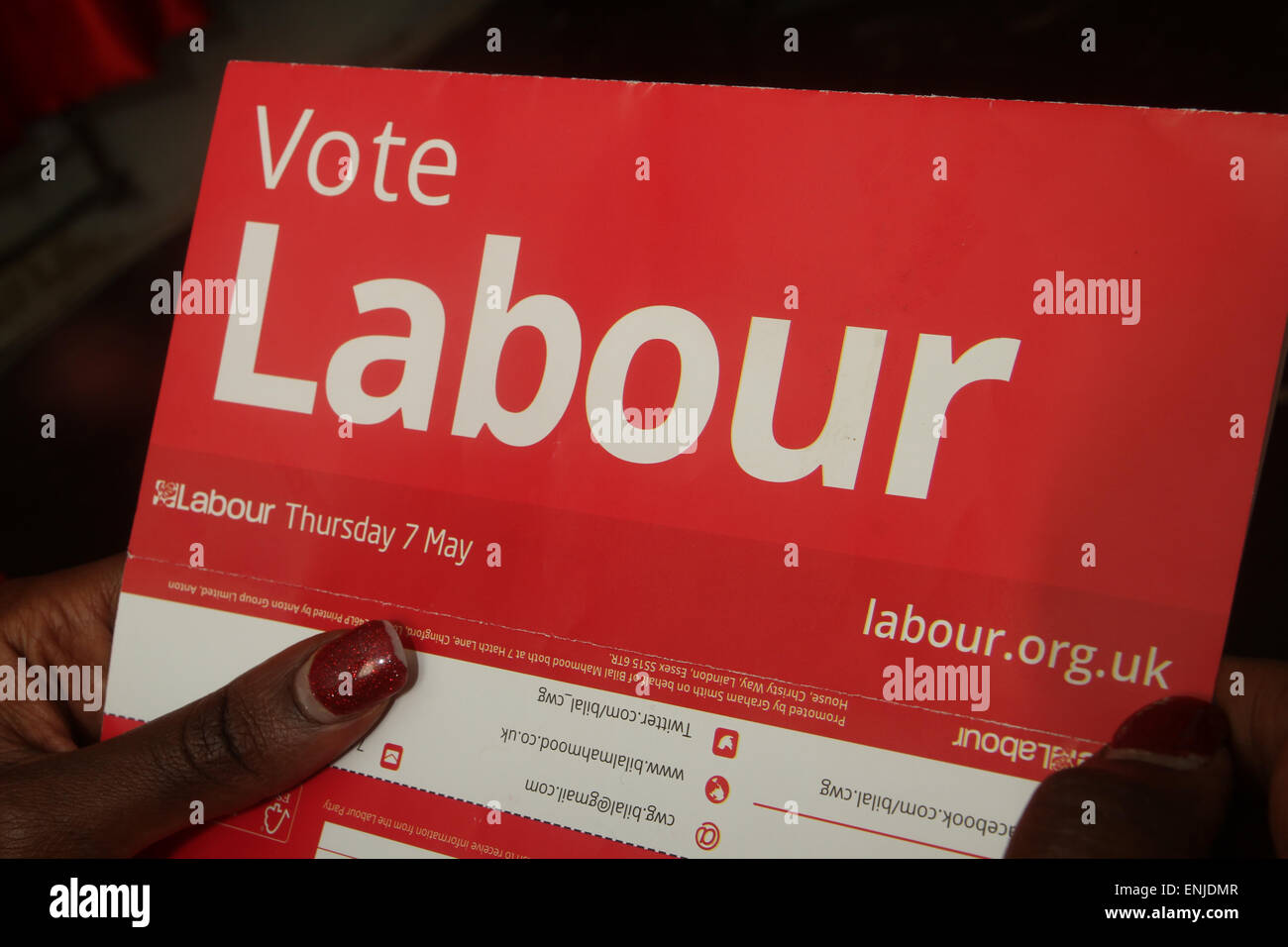 London, UK. 6 May 2015. An immigrant voter reads a Labour election flyer. Voters in the UK prepare to go to the polls on Thursday 7 May, in an election seen as one of the closest-fought in years. Britain's two-party system appears under severe threat, with the distinct prospect that between them Labour and the Conservatives will struggle to gain two-thirds of the votes cast. Compare that with their near 90% vote share just 50 years ago. Credit: David Mbiyu. immigrant voter reads a Labour election flyer. Voters in the UK prepare to go to the polls on Thursday 7 May, in an election seen as one o Stock Photo