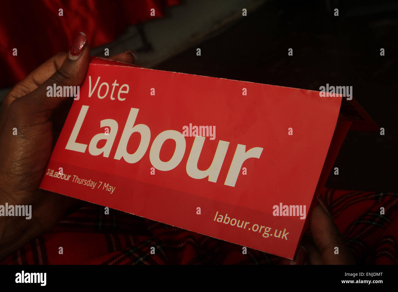 London, UK. 6 May 2015. A voter reads a Labour election flyer. Voters in the UK prepare to go to the polls on Thursday 7 May, in an election seen as one of the closest-fought in years. Britain's two-party system appears under severe threat, with the distinct prospect that between them Labour and the Conservatives will struggle to gain two-thirds of the votes cast. Compare that with their near 90% vote share just 50 years ago. Credit : David Mbiyu/ Alamy Live News Stock Photo