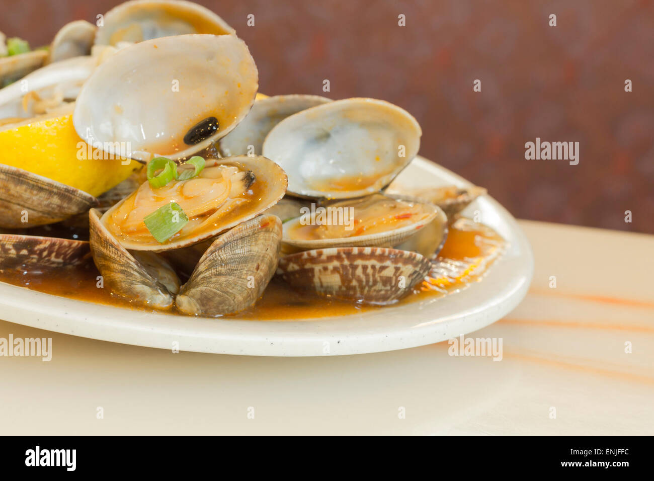 Chinese baby clams sauteed in sweet and spicy black bean sauce with lemon wedge Stock Photo Alamy