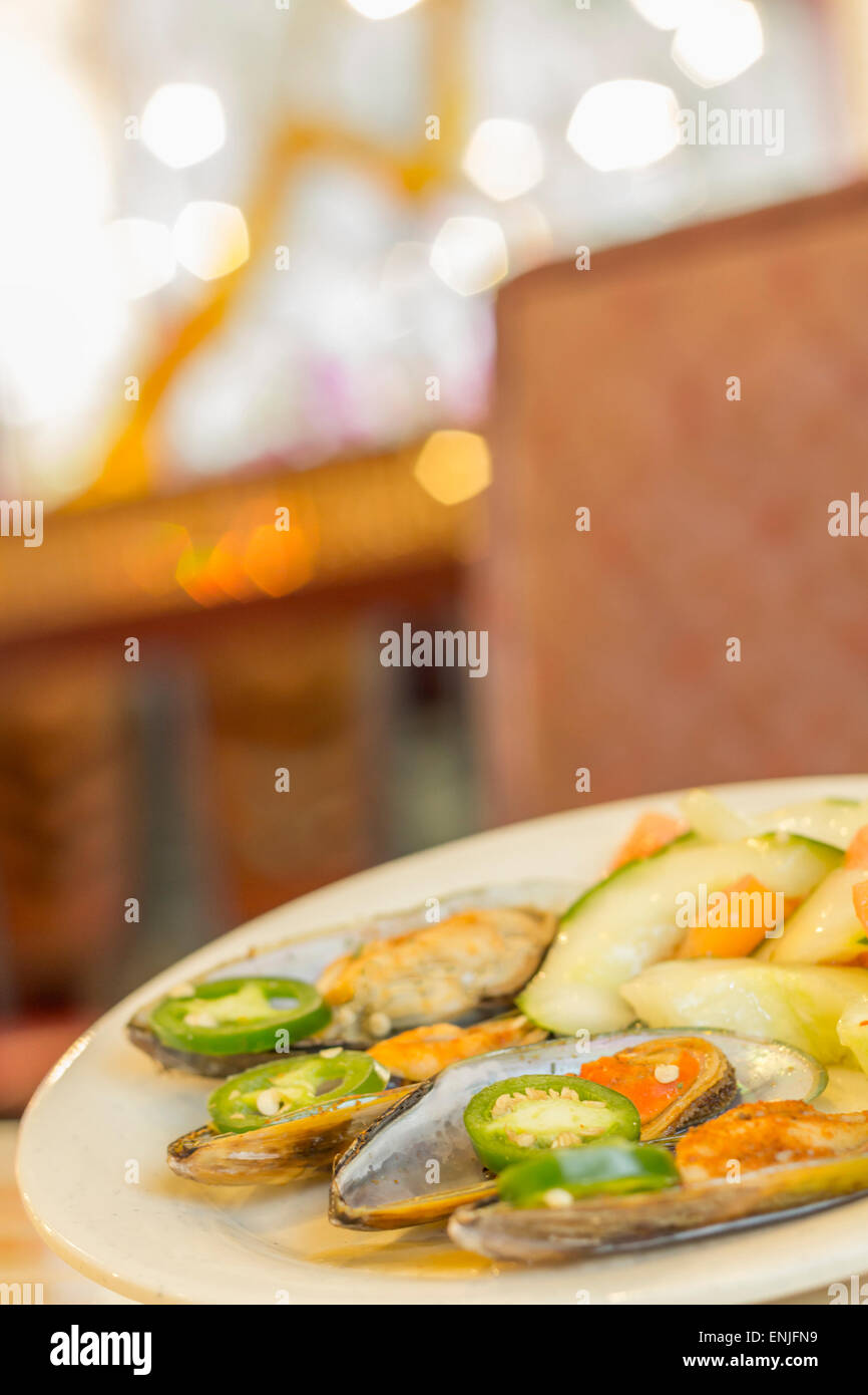 Spicy chili mussels with jalapeno slices and cucumber tomato salad