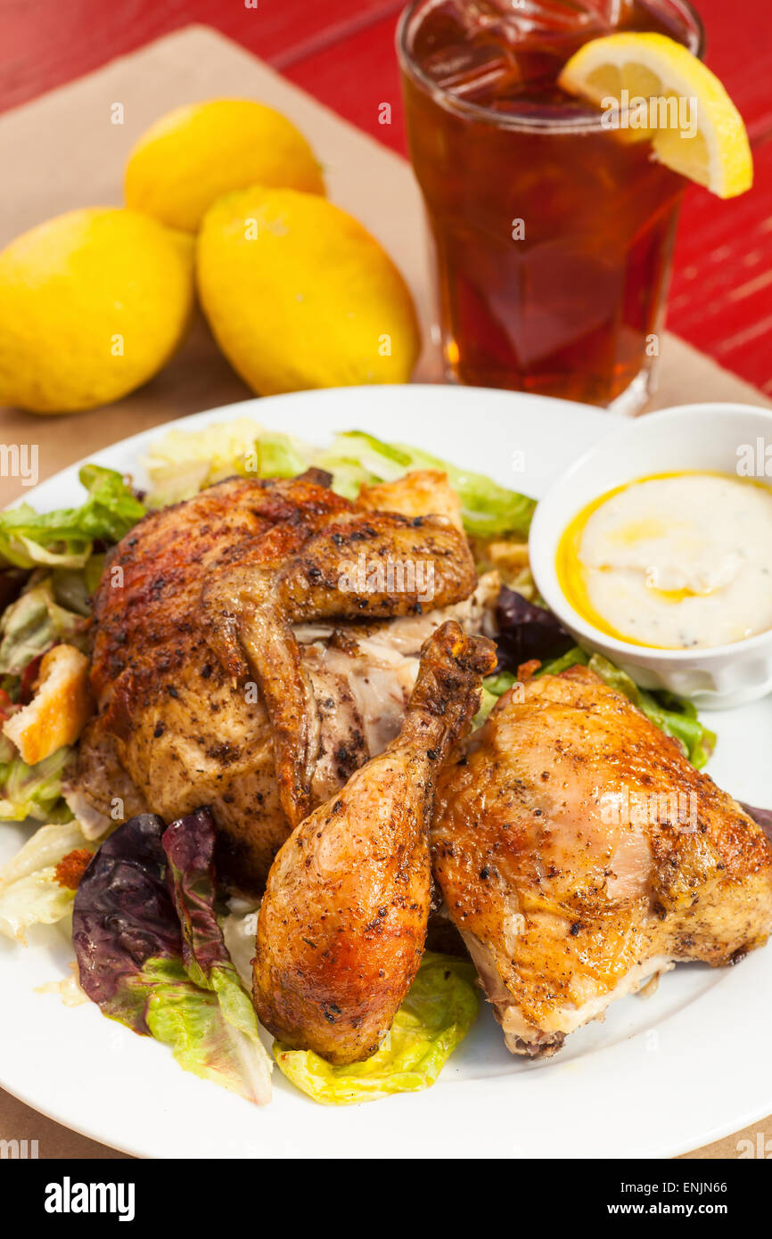 crispy rotisserie chicken on organic butter leaf salad with white bean hummus, glass ice tea, Bell Street Farm deli, Los Alamos Stock Photo