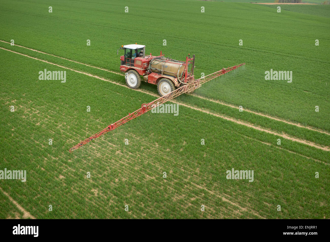 Aerial view of the tractor spraying the chemicals on the large green ...