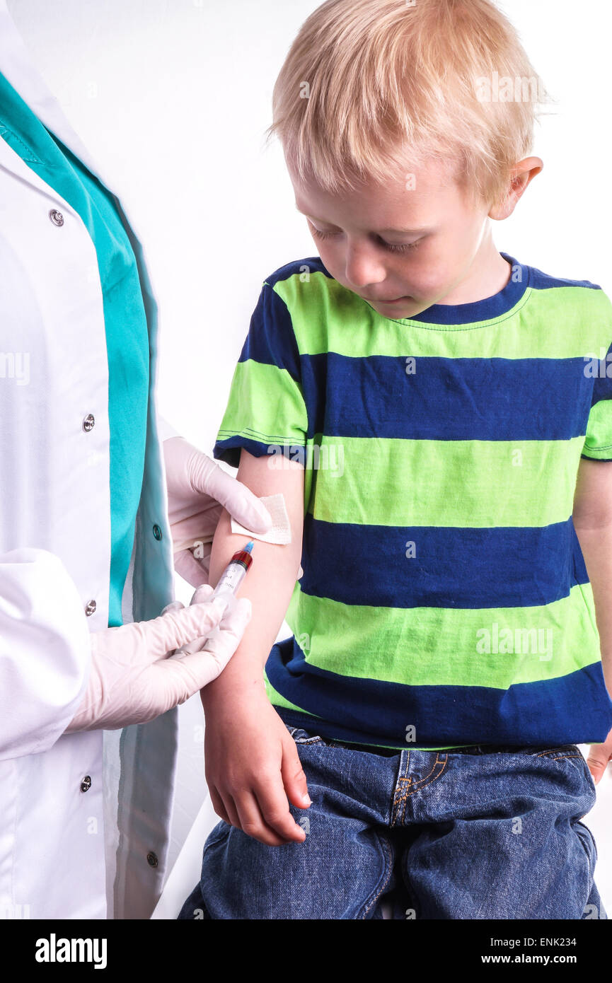 The child has a blood test . The blood sample taken by a lab technician