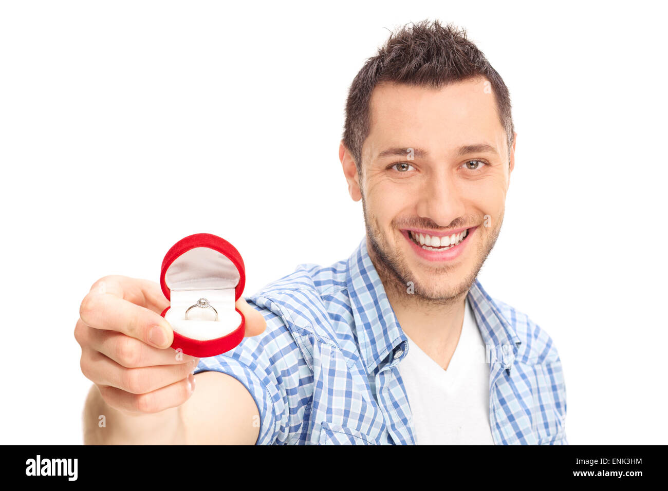 Young man holding an engagement ring and looking at the camera isolated on white background Stock Photo