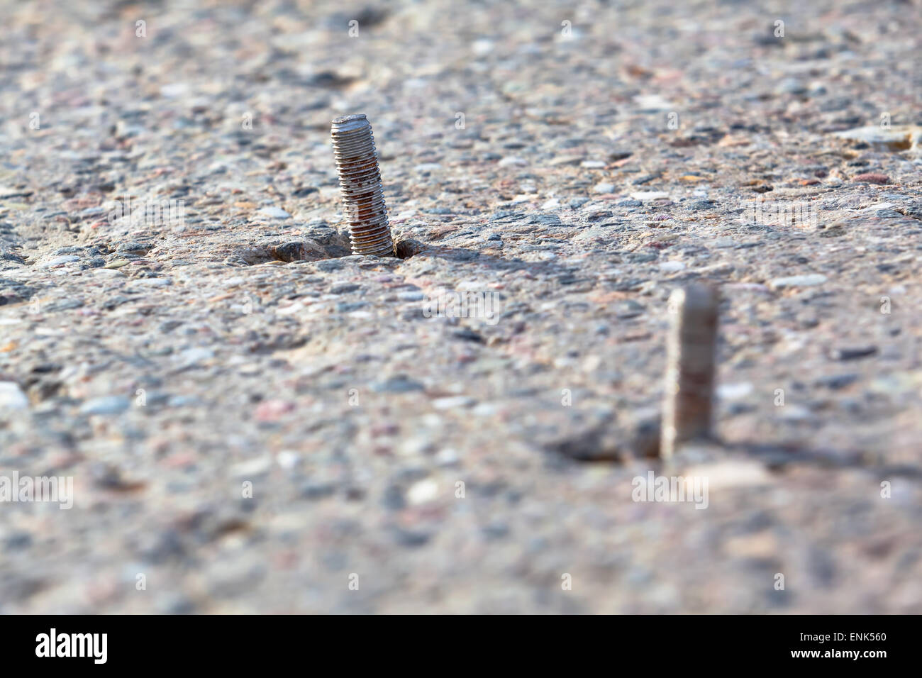Pair of screws partly inside a concrete slab foundation Stock Photo Alamy