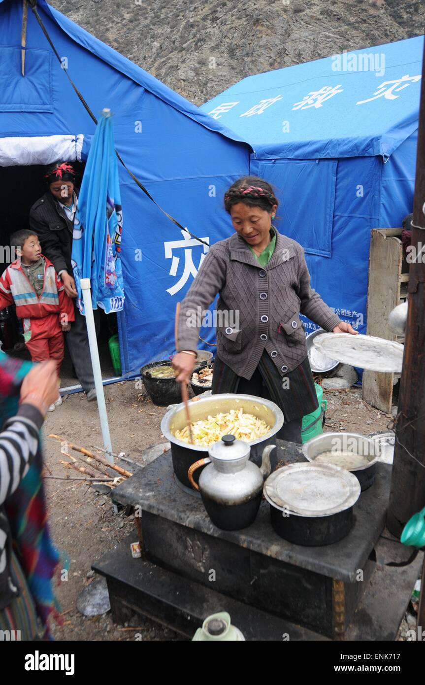 Tingri, China's Tibet Autonomous Region. 5th May, 2015. A woman cooks at a temporary shelter in Rongxia Township in Tingri, southwest China's Tibet Autonomous Region, May 5, 2015. More than 800 people in Rongxia have been well accommodated with safe food and drinking water. The region was severely hit by the April 25 Nepal earthquake. © Norbu Cering/Xinhua/Alamy Live News Stock Photo