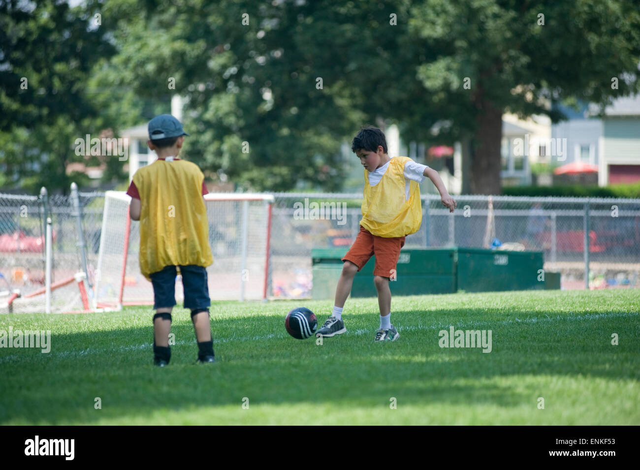 Seven year old boy kicks soccer ball at summer camp. (Boy kicking ball