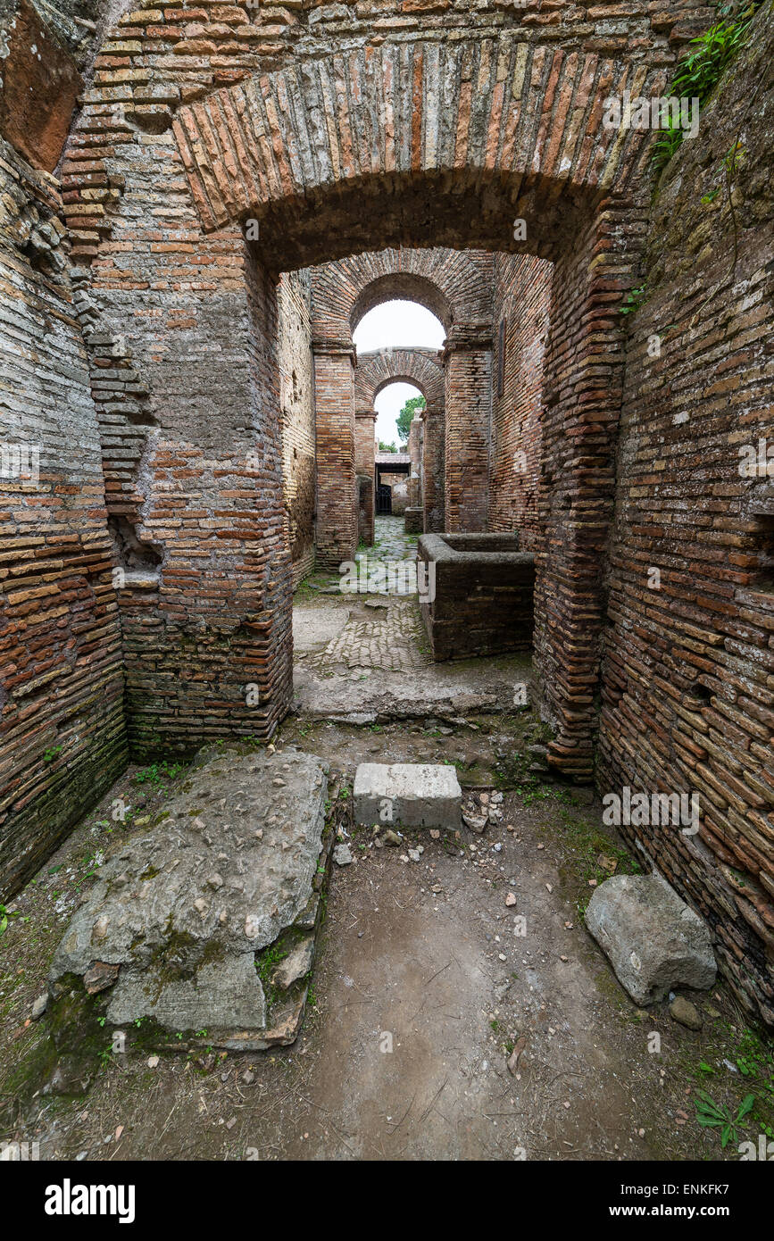 Ancient roman arches in row with alley and brick walls, weathered but restored, heritage of early italian history. Stock Photo