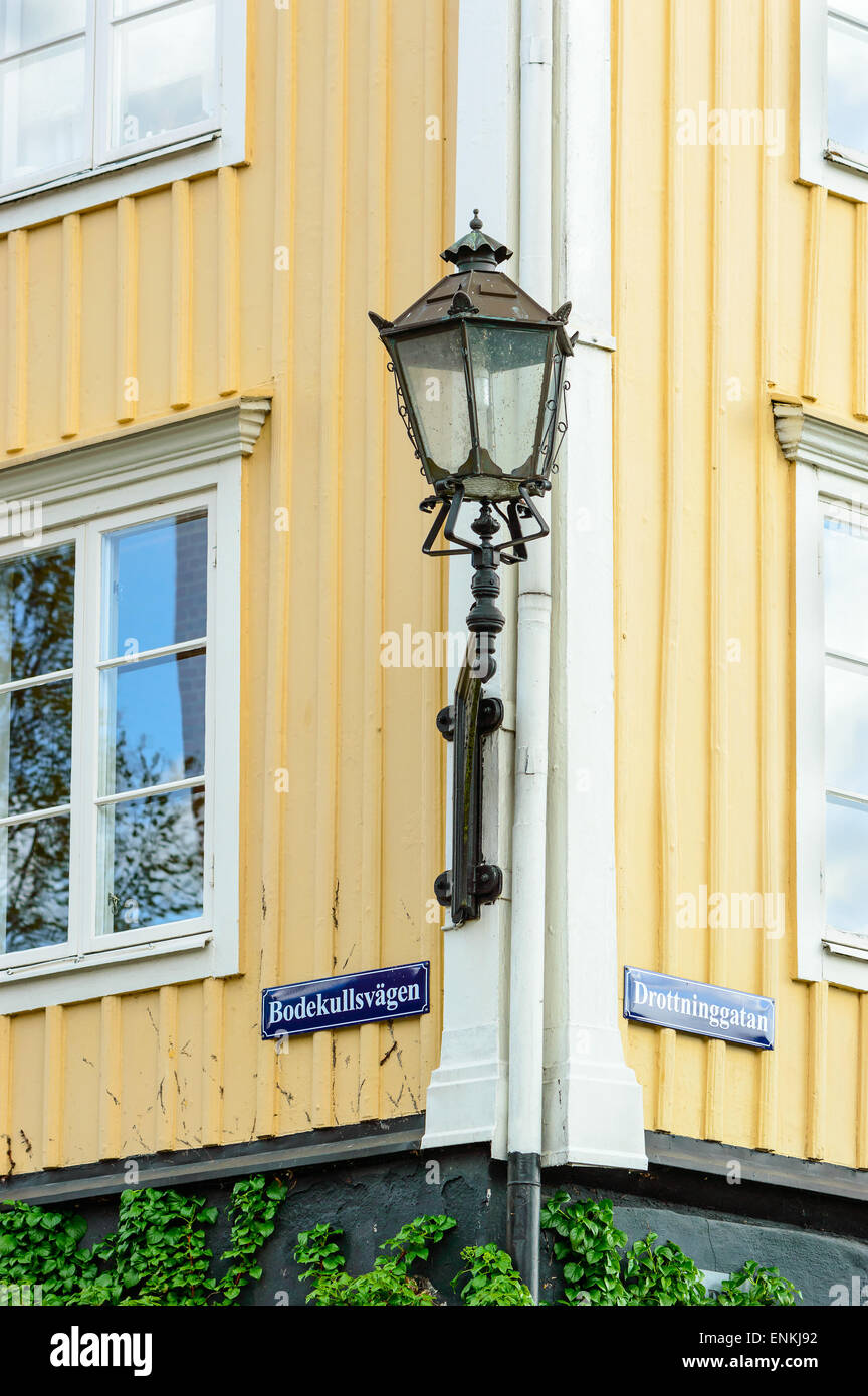 Very big lantern on the corner of a yellow and white building. Stock Photo