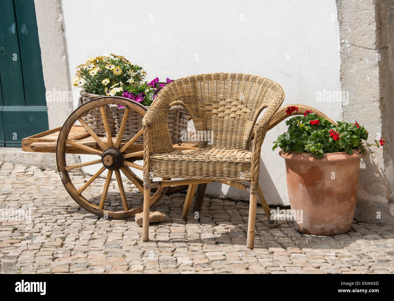 street in village in algarve portugal with flowers and wagon wheel car Stock Photo