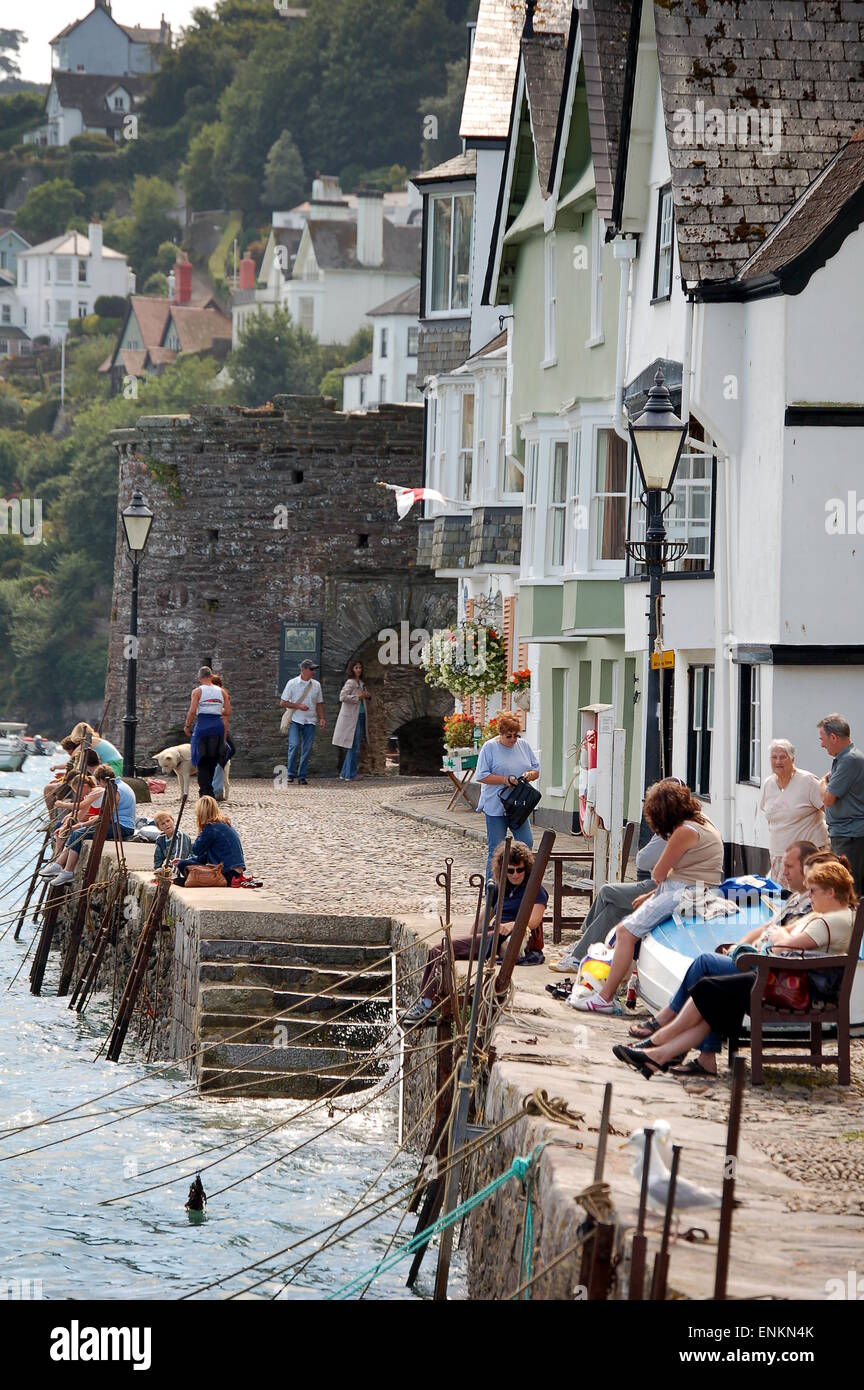 People sat and relaxing in Bayard's Cove, Dartmouth. Families catch crabs on the harbour wall. Stock Photo