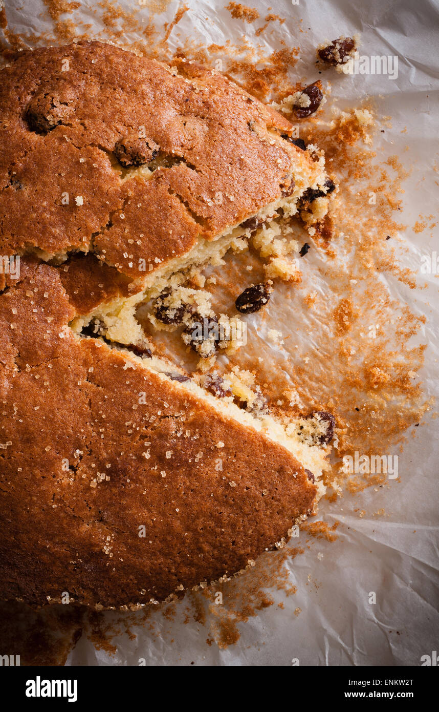 Traditionally home baked sultana or dried fruit light sponge cake with a slice removed Stock