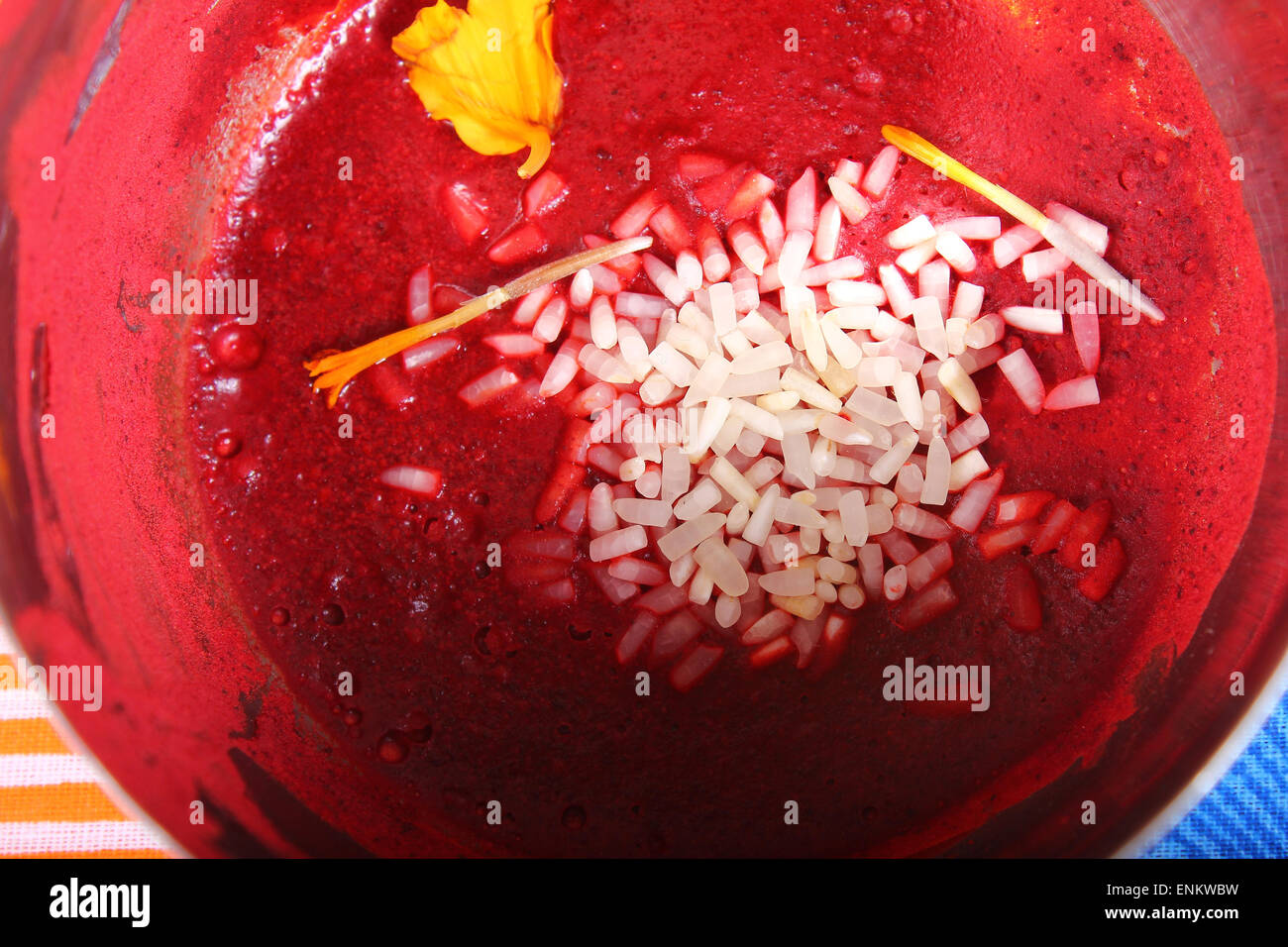 wet kumkum in bowl with rice and flowers Stock Photo