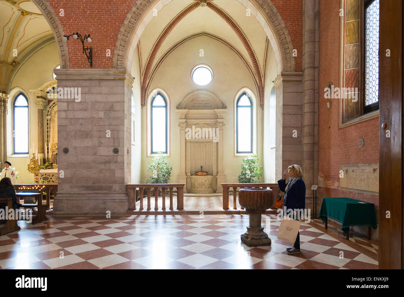 Vicenza,Italy-April 3,2015:A woman makes the sign of the cross before entering in the dome of Santa Maria Annunziata in the cent Stock Photo