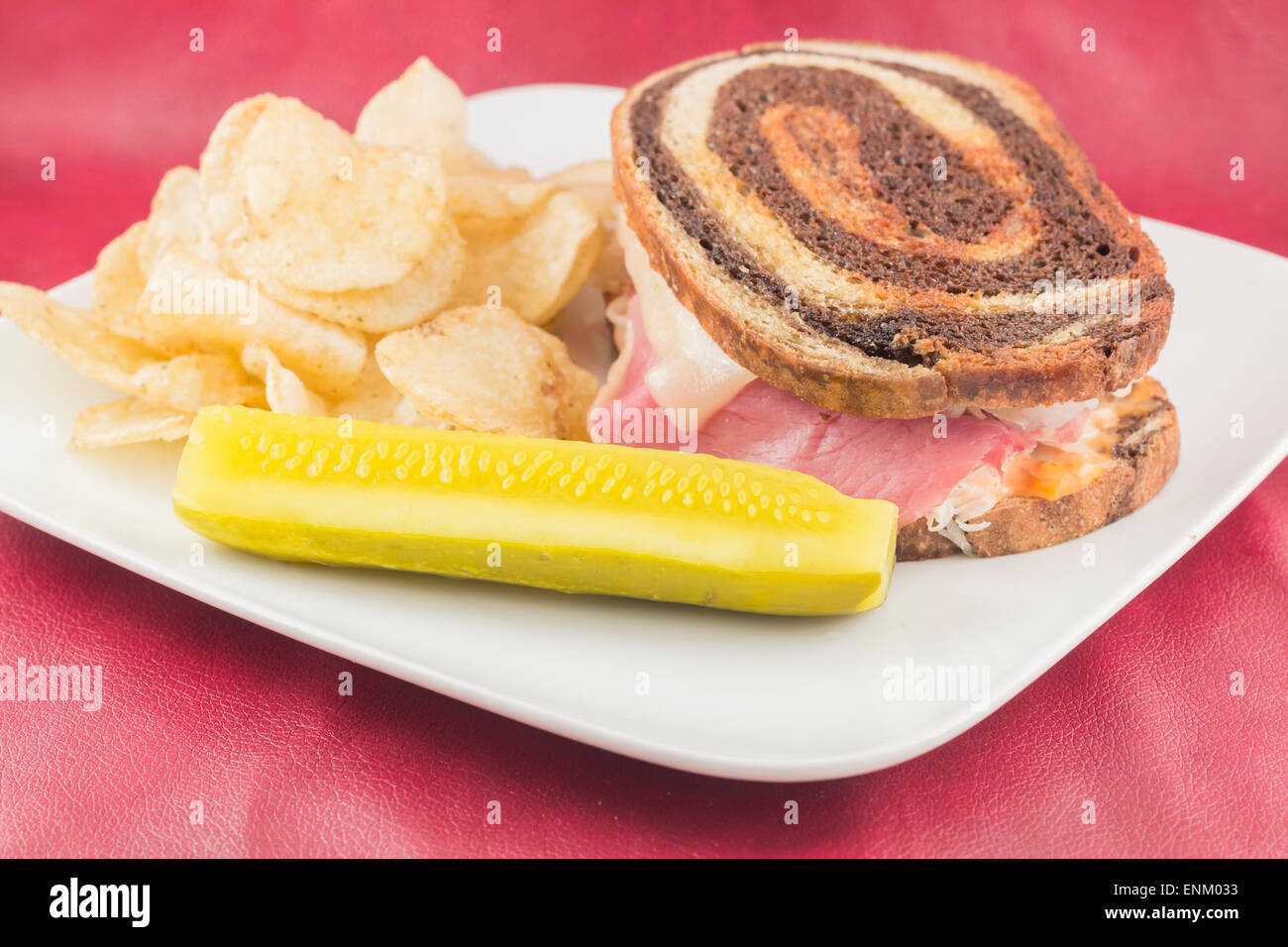 Classic reuben sandwich on pumpernickel swirl rye bread. A hearty meal with a side of pickle and