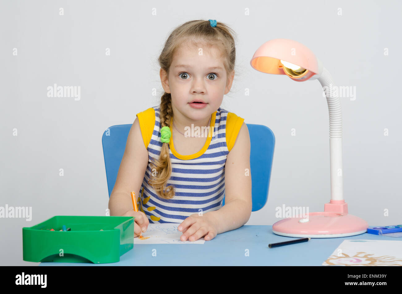 Four-year girl Europeans draws pencil on a sheet, sitting at the table Stock Photo