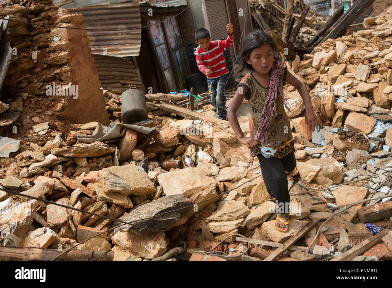Children run through the streets of Chautara town in Sindhulpalchowk District, Nepal following the 2015 earthquake. Stock Photo