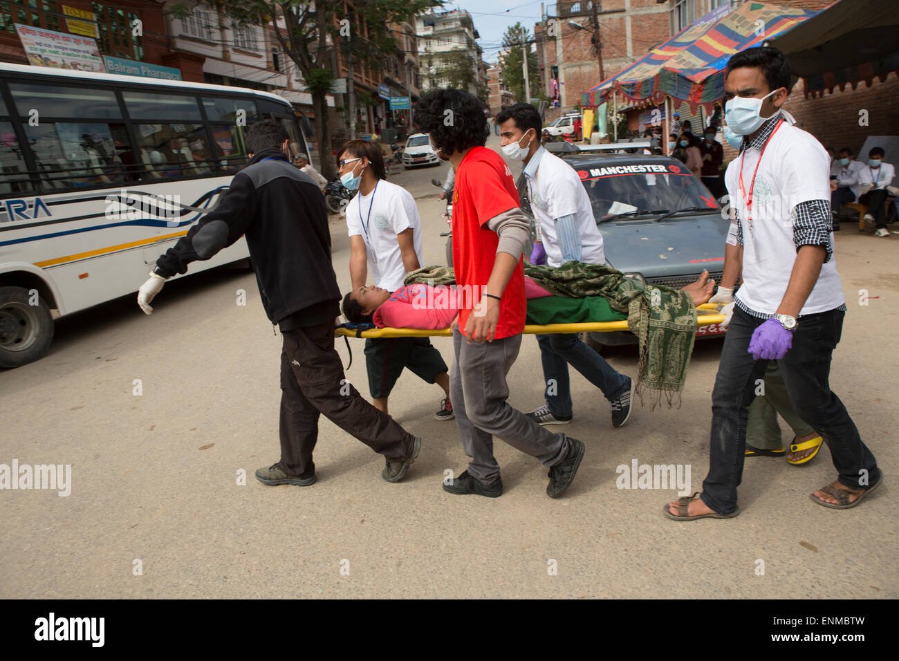 An injured woman is carried on a stretcher outside Kathmandu University Hospital in Karvre District, Nepal. Stock Photo