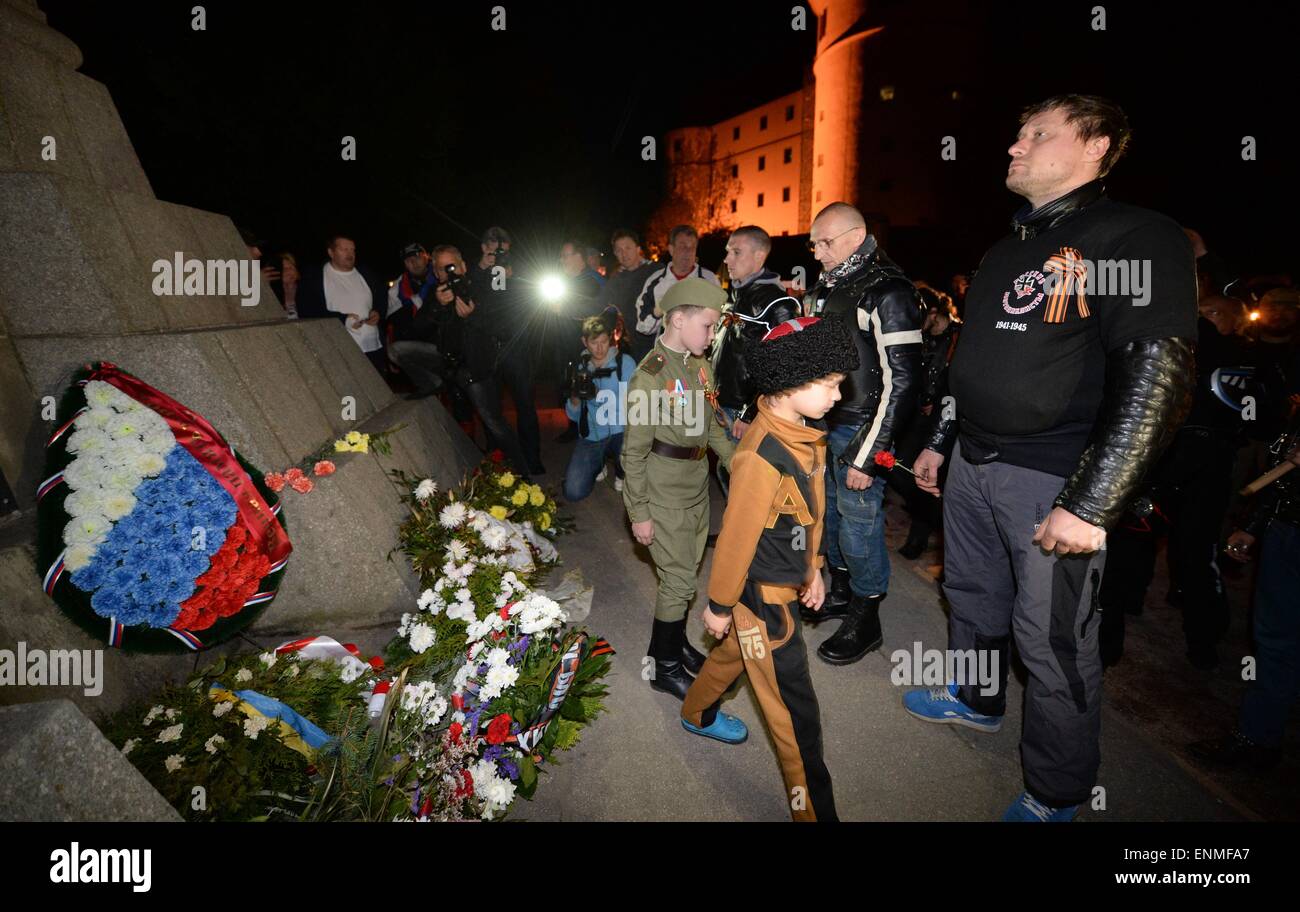 Torgau, Germany. 7th May, 2015. Members and sympathizers of the Russian motorcycle club 'Night Wolves' place flowers as they stand in front of the Soviet cenotaph in Torgau, Germany, 7 May 2015. The group is on a tour from Moscow to Berlin. They want to arrive in the German capital on 09 May 2015 - when Russia observes the day of victory over Hitler's Germany. Photo: Hendrik Schmidt/dpa/Alamy Live News Stock Photo