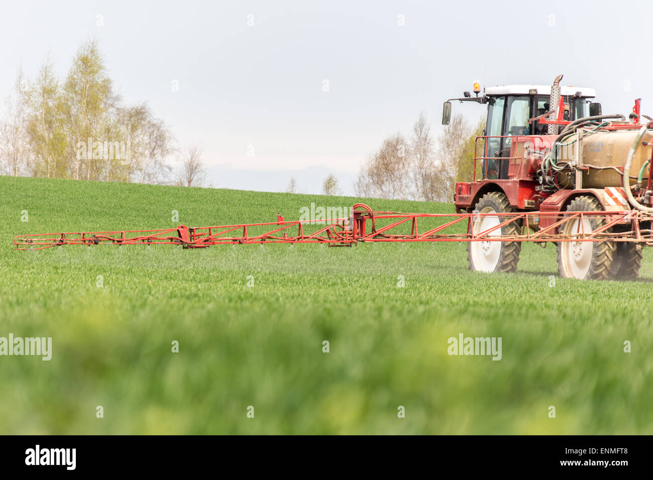 Spraying the herbicides on the green field Stock Photo