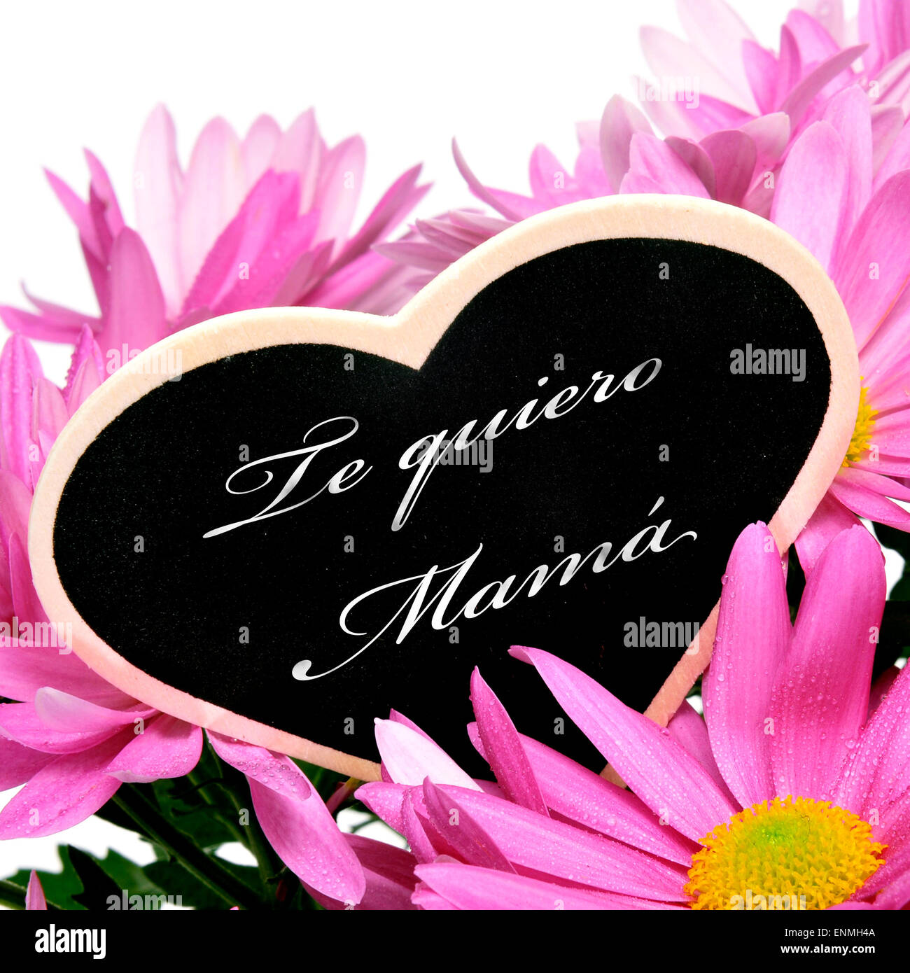 sentence te quiero mama, I love you mom in spanish, written with chalk on a heart-shaped blackboard on a bouquet of pink chrysan Stock Photo
