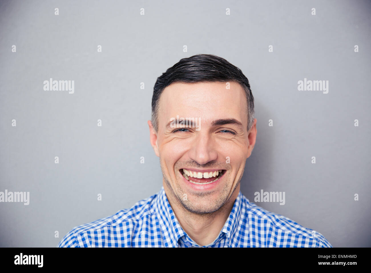 Portrait of a laughing man over gray background. Looking at camera Stock Photo