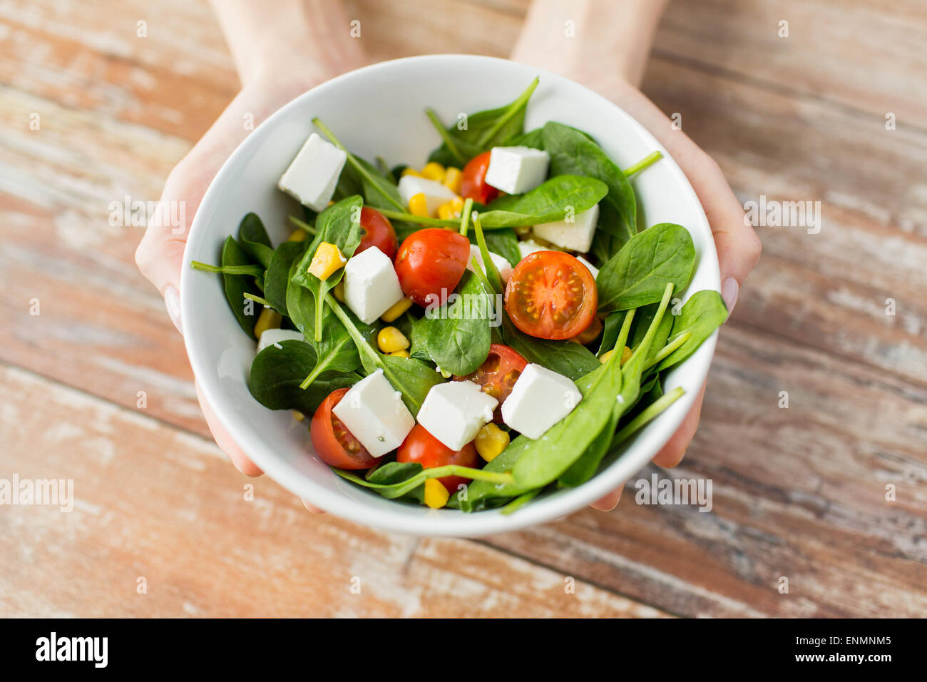close up of young woman hands showing salad bowl Stock Photo