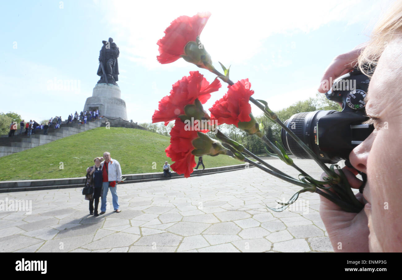 Berlin, Germany. 8th May, 2015. Visitors from Russia with red cloves in their hands take pictures of the Soviet cenotaph to commemorate the anniversary of the official end of World War II on 8 May 1945, in the Treptower Park in Berlin, Germany, 8 May 2015. Numerous demonstrations and events are taking place in and around Berlin to commemorate the end of World War II, 70 years ago. Photo: STEPHANIE PILICK/dpa/Alamy Live News Stock Photo