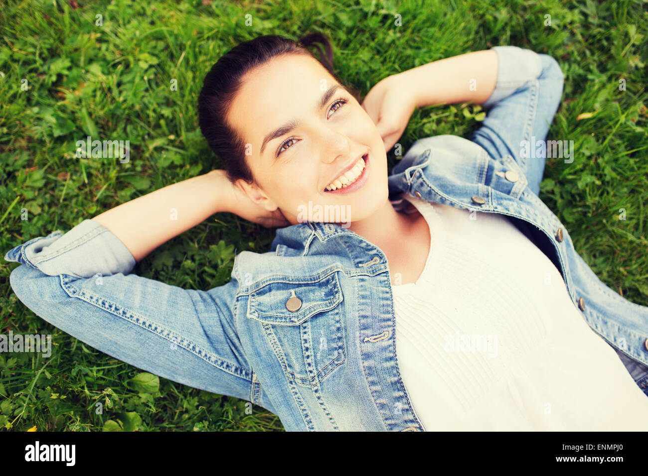 smiling young girl lying on grass Stock Photo - Alamy