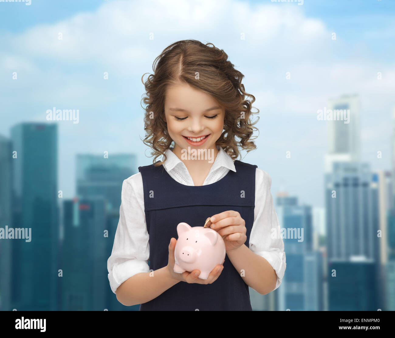 happy girl putting coin into piggy bank Stock Photo - Alamy