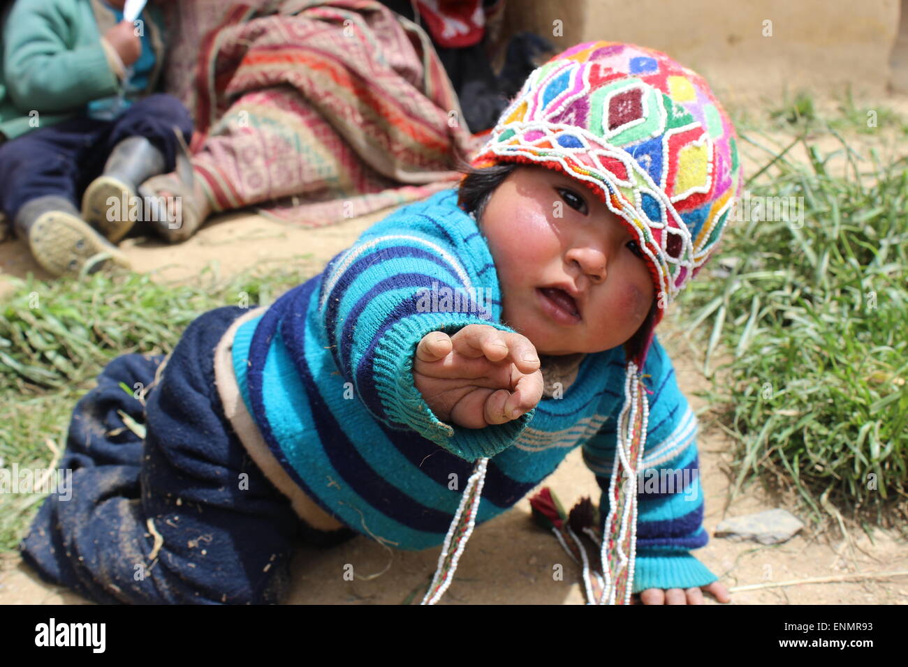Adorable little Peruvian baby reaching out for the camera. Stock Photo
