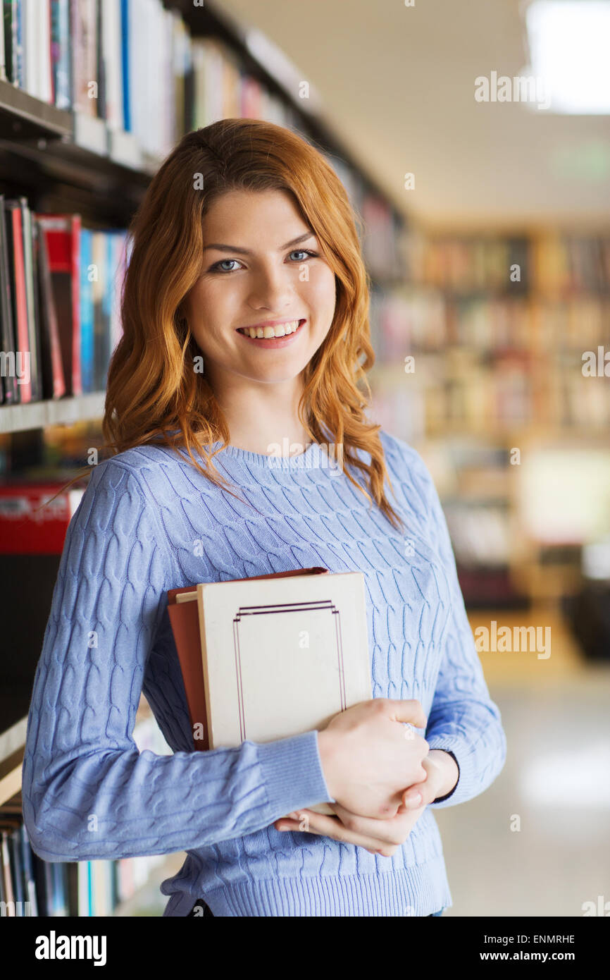happy student girl or woman with book in library Stock Photo - Alamy