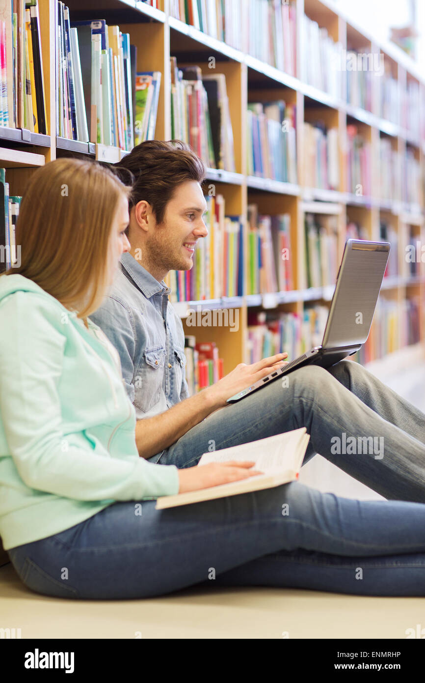 happy students with laptop in library Stock Photo - Alamy