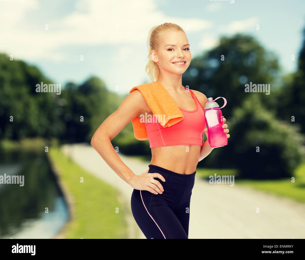 smiling sporty woman with water bottle and towel Stock Photo - Alamy