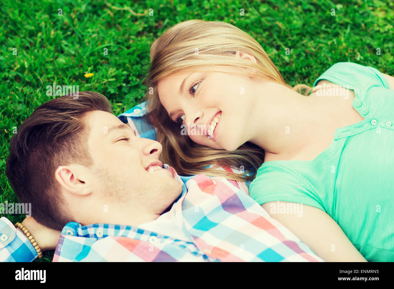 smiling couple lying on grass in park Stock Photo - Alamy