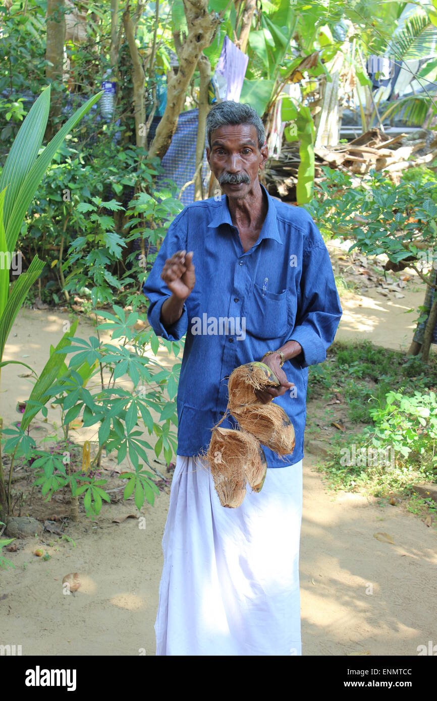 A day out on the Kerala Backwaters. A tour guide explains coconut fibre uses. Stock Photo
