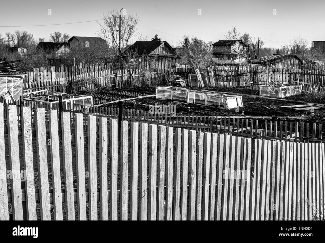 Rustic garden plots with vertical wooden slat boundary markers in black and white Stock Photo