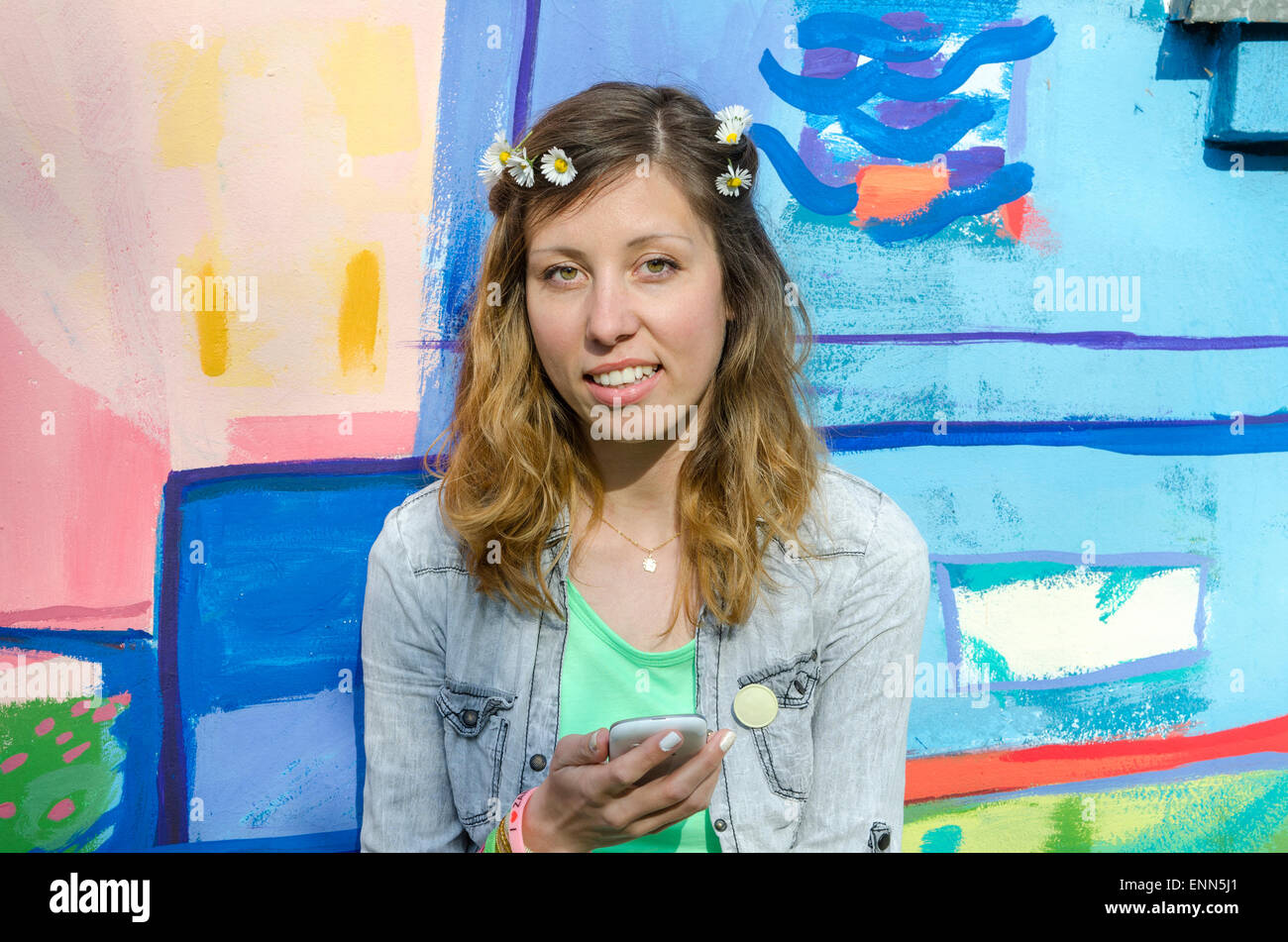 Young posing against a colorful backdrop holding smart phone Stock Photo