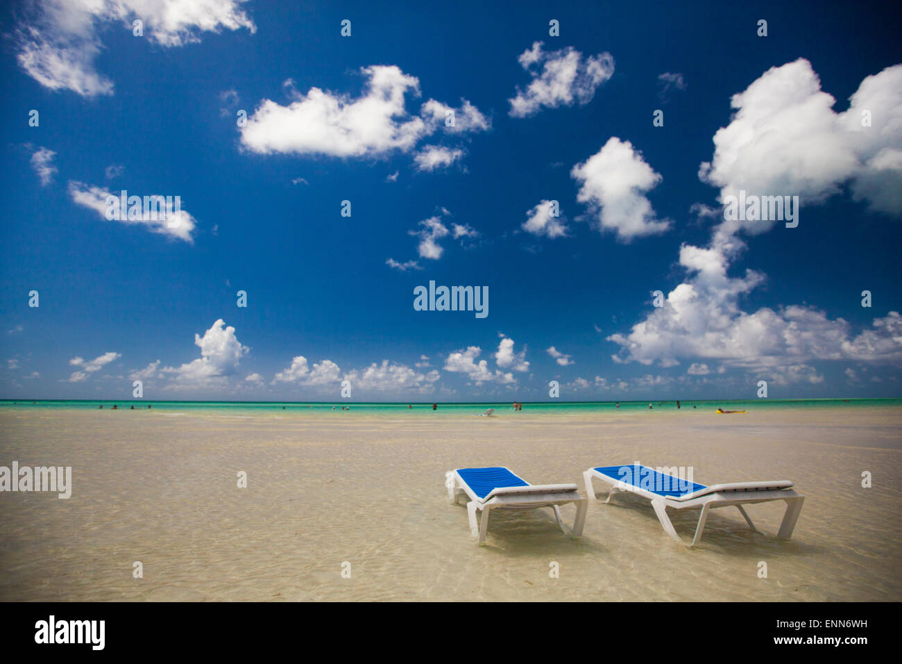 Two empty beach chairs in ankle deep water face the ocean in Cayo Coco, Cuba. Stock Photo