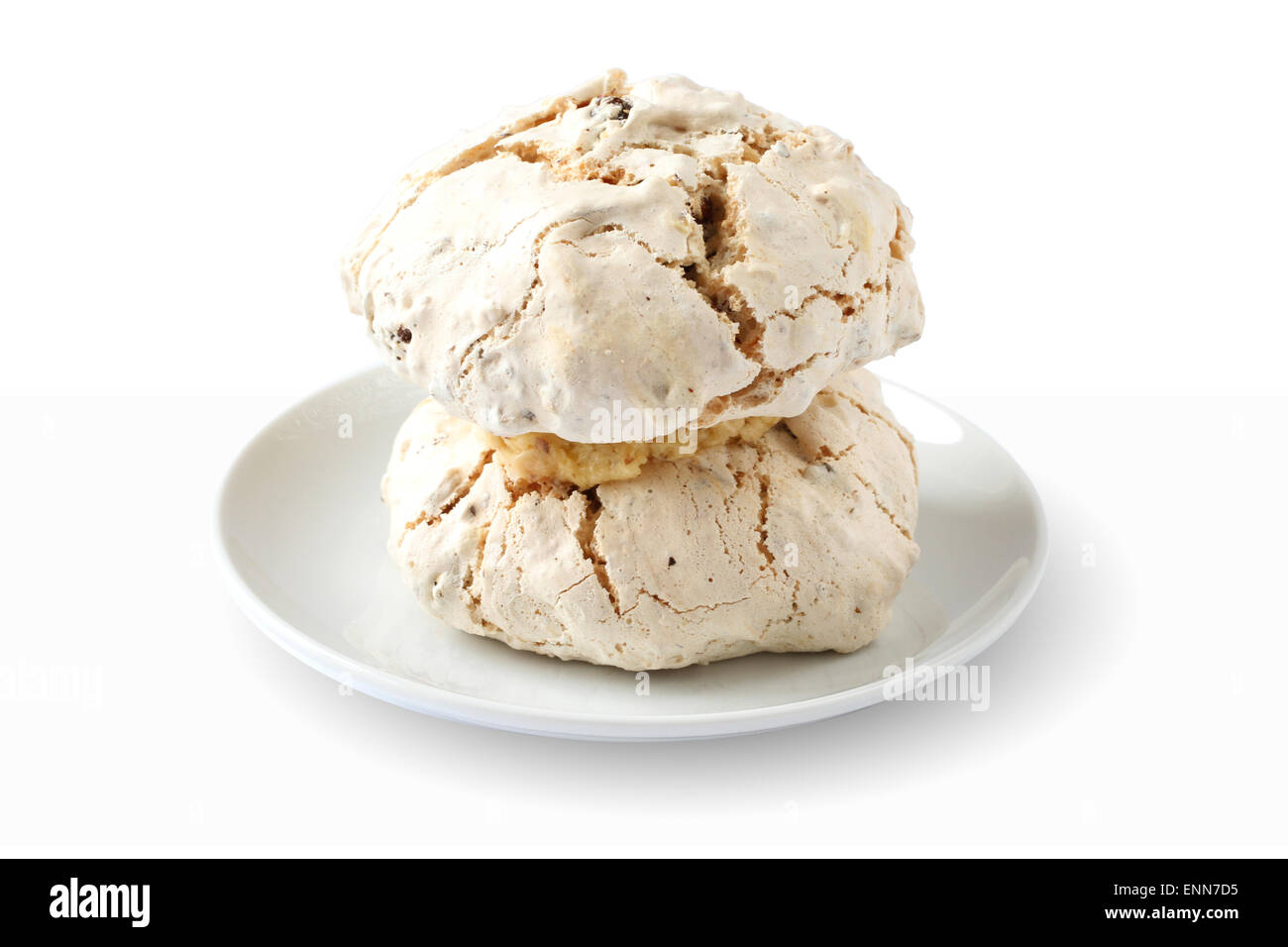 Cake meringue with hazelnuts and dates on white plate against white background Stock Photo