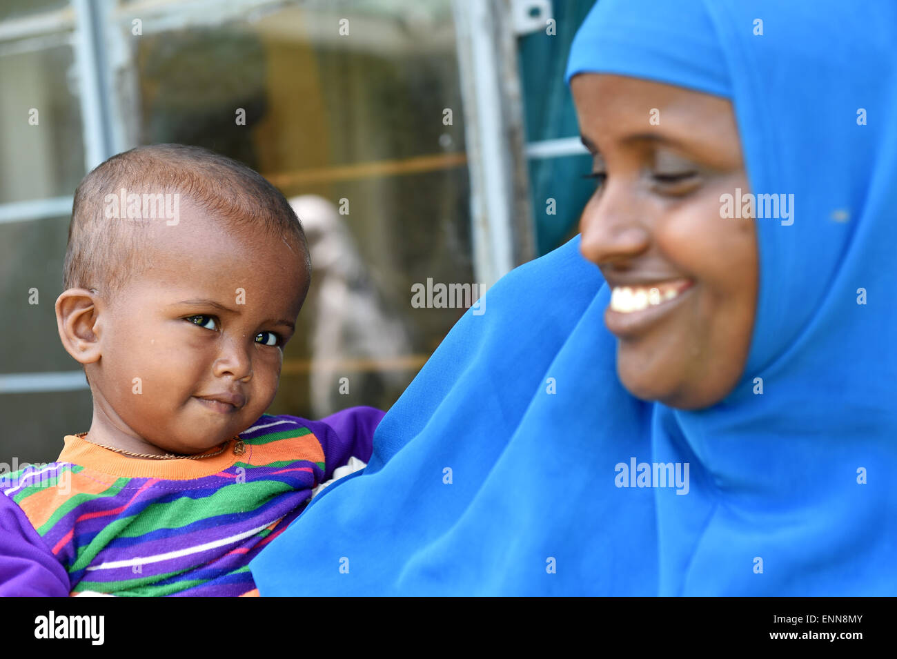 (150508) --DADAAB, May 8, 2015 (Xinhua) -- A refugee child smiles with his mother at Dadaab refugee camp, Kenya, May 8, 2015. Dadaab, the world's largest refugee camp in northeastern Kenya, currently houses some 350,000 people. For more than 20 years, it has been home to generations of Somalis who have fled their homeland wracked by conflicts. (Xinhua/Sun Ruibo) Stock Photo