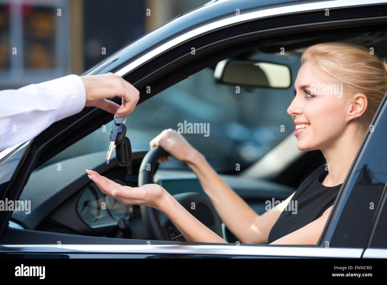 Car dealer giving keys to happy woman Stock Photo - Alamy