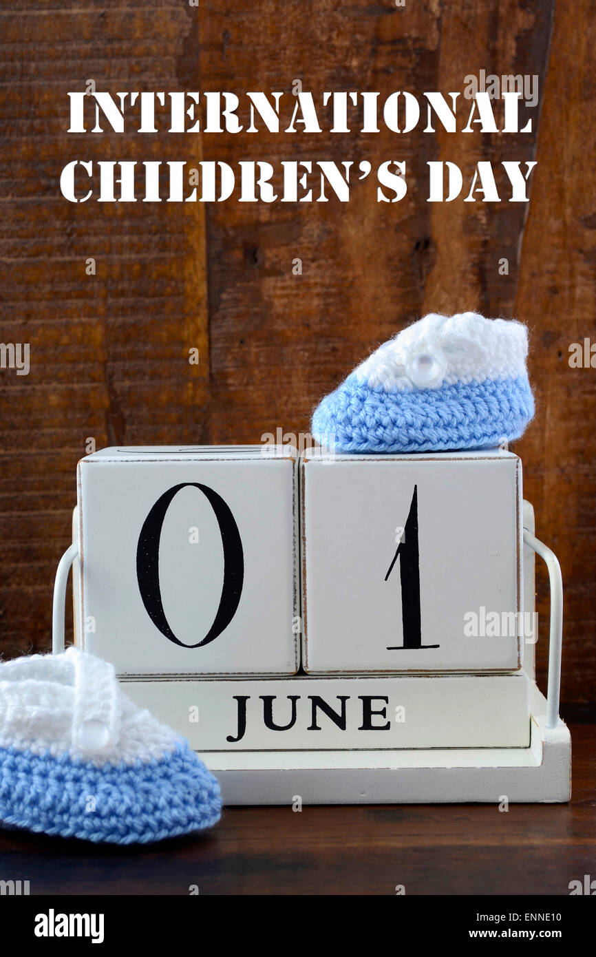 International Childrens Day concept with June First Calendar and child booties on dark wood rustic background. Stock Photo