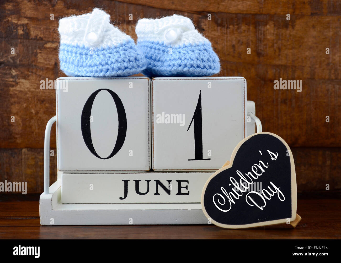 International Childrens Day concept with June First Calendar and child booties on dark wood rustic background. Stock Photo