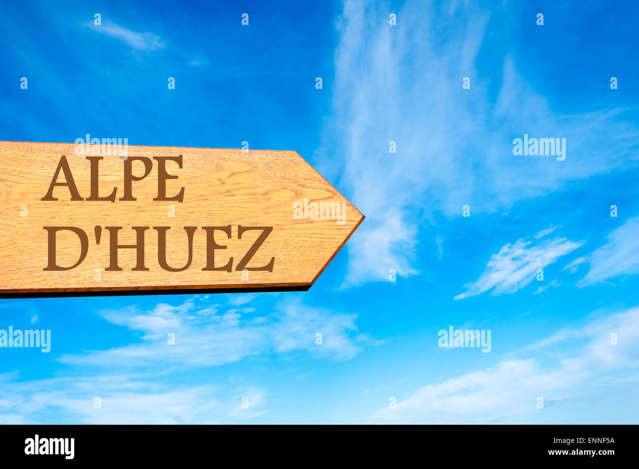 Wooden arrow sign pointing destination ALPE D'HUEZ, FRANCE against clear blue sky with copy space available. Travel destination conceptual image Stock Photo