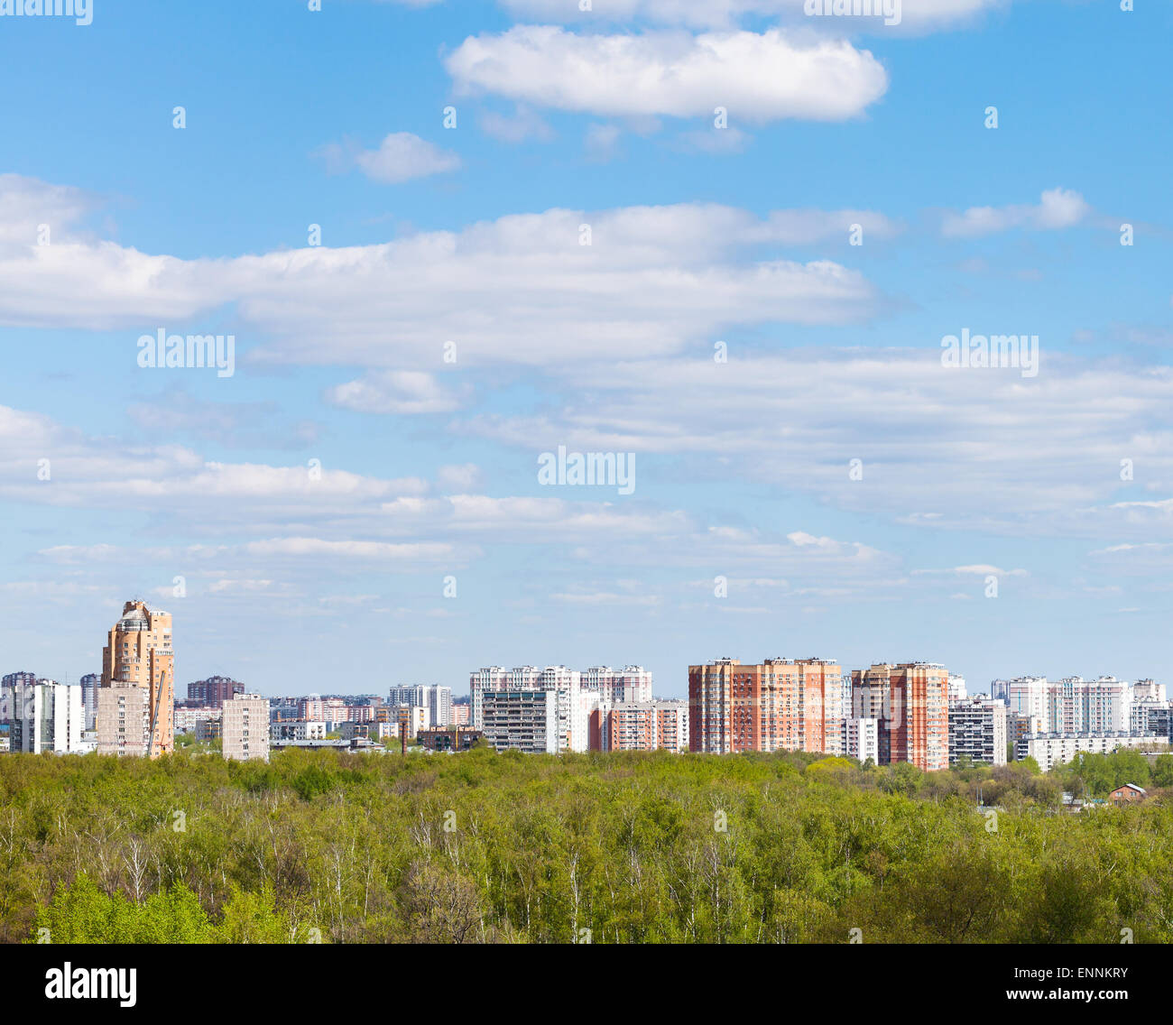 blue sky with white clouds over city and green forest in sunny spring ...